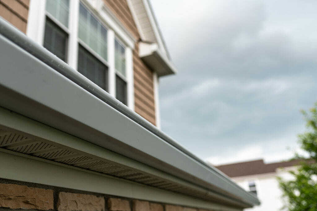 Hooded gutter and eave flashing along the fascia and vented soffit of a Columbus home